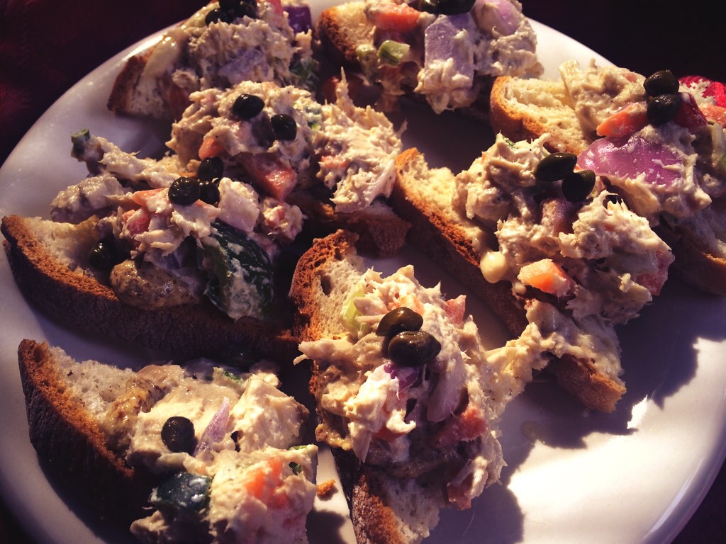 Vegan "tuna" salad on gluten free crostini, garnished with capers.